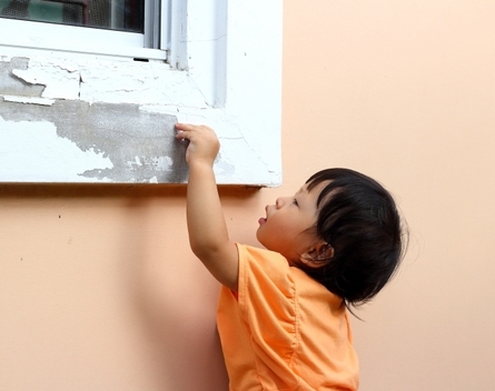 child peeling paint